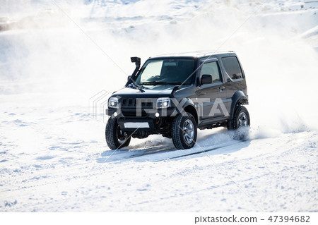 Black SUV rally race at frozen river in winter 47394682