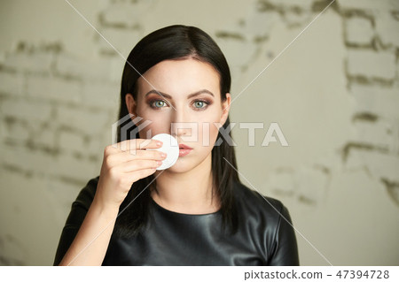 Young girl remove mascara. Face with cotton pad 47394728