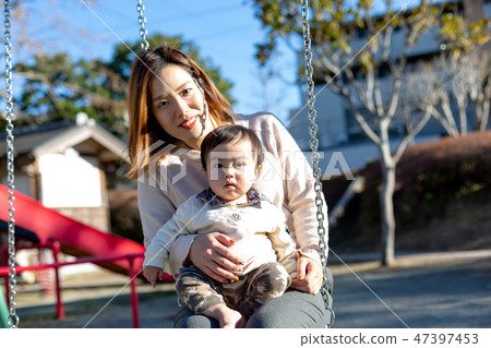 Parent and child playing in the park 47397453