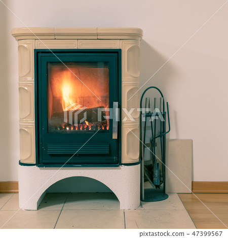 Tiled stove with fire burning inside Tiled stove with fire burning inside 47399567