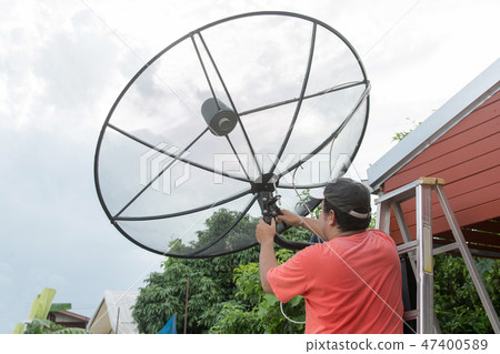 Man technicians are installing satellite dish 47400589