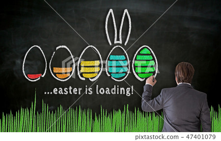 Businessman paints with chalk Easter concept on blackboard Businessman paints with chalk Easter concept on blackboard 47401079