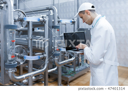 Technologist with a laptop in his hands at the dairy plant Technologist with a laptop in his hands at the dairy plant 47401314