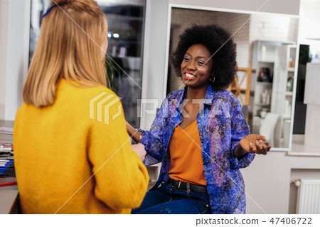 Beautiful dark-skinned stylist in an orange top feeling great Beautiful dark-skinned stylist in an orange top feeling great 47406722