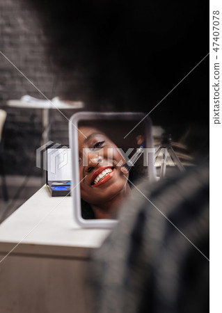Cute dark-skinned woman with coral lipstick smiling positively Cute dark-skinned woman with coral lipstick smiling positively 47407078