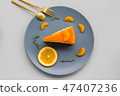 A sliced piece of orange cake on grey dish  47407236