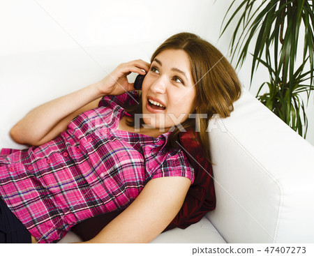 young pretty woman at home smiling happy, laying on coach, lifestyle people concept 47407273