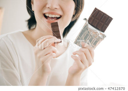 吃巧克力的一名年輕日本婦女 47412870