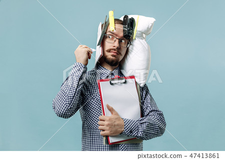 Tired man sleeping at home having too much work. Bored businessman with pillow 47413861