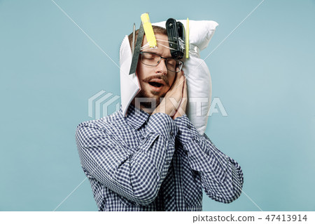 Tired man sleeping at home having too much work. Bored businessman with pillow 47413914
