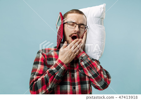 Tired man sleeping at home having too much work. Bored businessman with pillow Tired man sleeping at home having too much work. Bored businessman with pillow 47413918