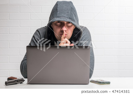 portrait of a criminal hacker with a notebook portrait of a criminal hacker with a notebook 47414381