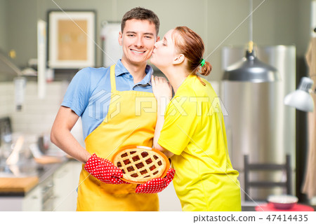 a man in an apron with a pie and her beloved wife 47414435