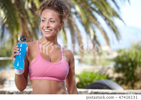 fitness and dieting concept - smiling sporty woman with bottle o fitness and dieting concept - smiling sporty woman with bottle o 47416131