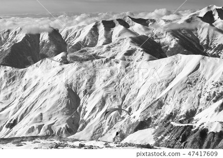 Speed flying at snowy mountains over ski resort 47417609