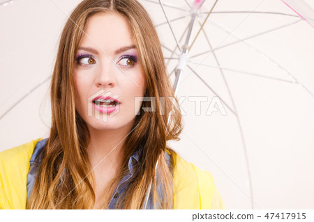 Woman wearing waterproof coat holding umbrella Woman wearing waterproof coat holding umbrella 47417915