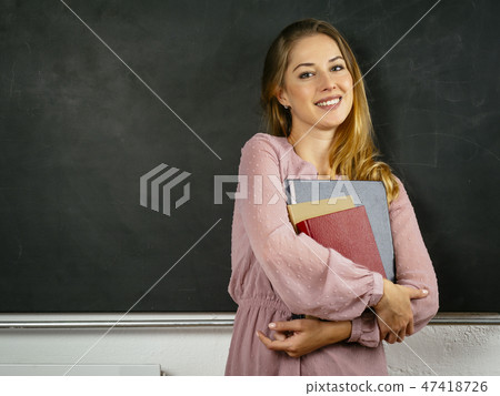 Beautiful happy student in front of blackboard 47418726