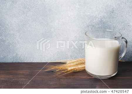 Glass of milk and wheat branches on rustic  47420547