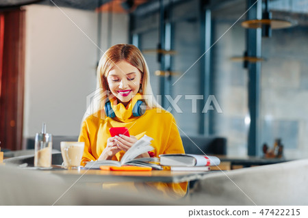 Beaming woman feeling happy after reading message from boyfriend Beaming woman feeling happy after reading message from boyfriend 47422215