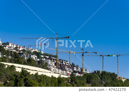 Many cranes silhouettes on clear and blue sky Many cranes silhouettes on clear and blue sky 47422270