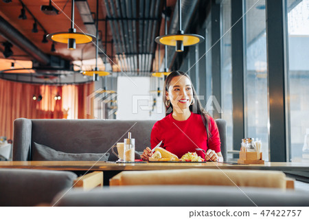 Beaming woman with red lips eating tasty lunch in restaurant Beaming woman with red lips eating tasty lunch in restaurant 47422757