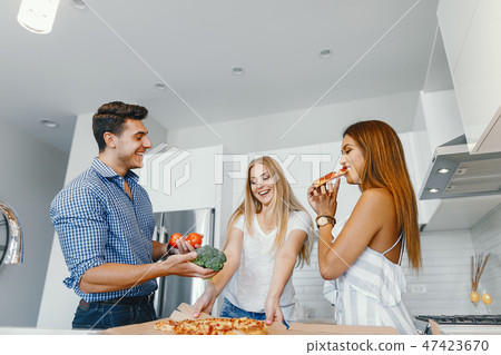 friends eatting in a kitchen friends eatting in a kitchen 47423670