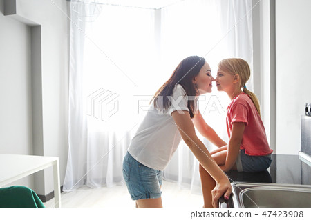Mother and daughter on modern kitchen background Mother and daughter on modern kitchen background 47423908