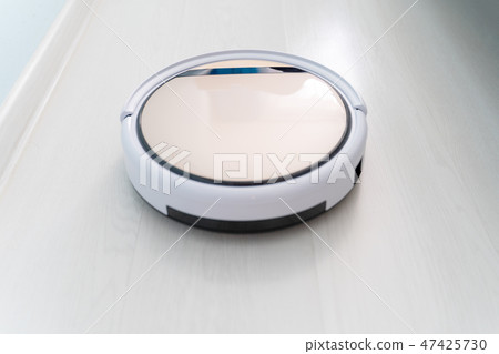Robotic vacuum cleaner cleaning laminate wood floor. 47425730