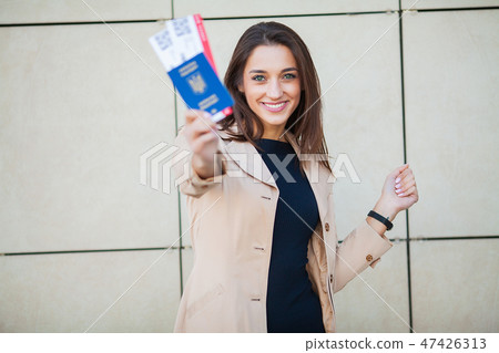 Business woman holding air tickets. Traveller walking the airport hall 47426313