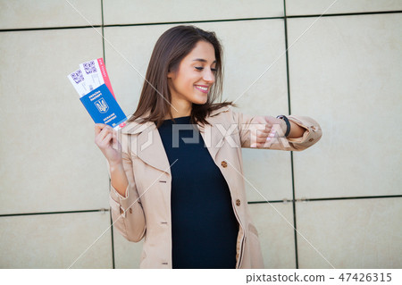 Image of European Woman Having Beautiful Brown Hair Smiling While Holding Passport and Air Tickets Image of European Woman Having Beautiful Brown Hair Smiling While Holding Passport and Air Tickets 47426315