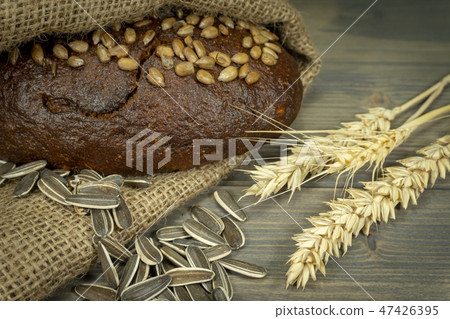 Bread with sunflowers on rustic wooden table 47426395