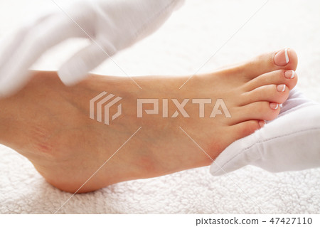 Pedicure day. Master using professional instruments when doing pedicure. Pedicure day. Master using professional instruments when doing pedicure. 47427110