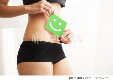 Women Health. Closeup Of Healthy Female With Beautiful Fit Slim Body In Black Panties Holding Green Women Health. Closeup Of Healthy Female With Beautiful Fit Slim Body In Black Panties Holding Green 47427660