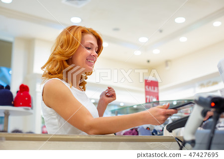 Wireless payment using smartphone and NFC technology. Close up. Female customer paying with smart 47427695