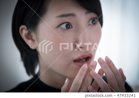 A young Japanese lady with frightened expression 47433241