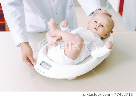 doctor weighting cute baby at home 47433718
