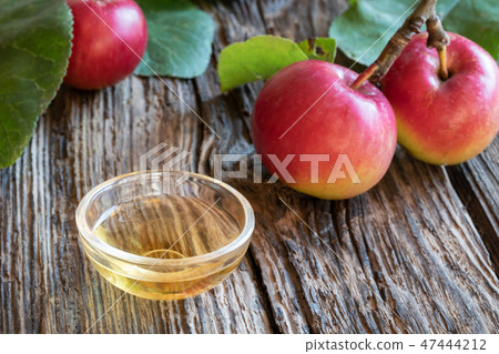 A bowl of apple cider vinegar with fresh apples A bowl of apple cider vinegar with fresh apples 47444212