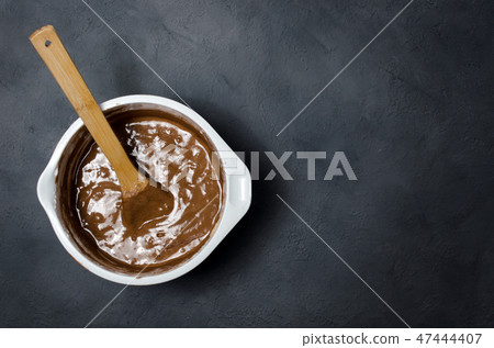 Cake pan with chocolate batter and wooden spoon Cake pan with chocolate batter and wooden spoon 47444407