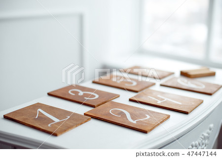 Vintage rectangular shaped wooden number buttons on a white wooden table. 47447144