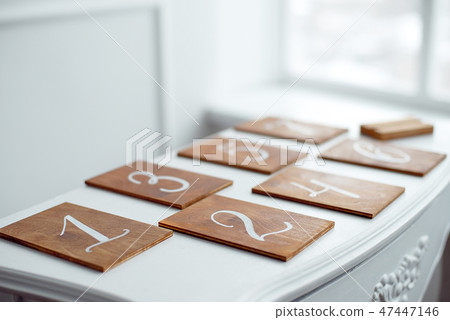Vintage rectangular shaped wooden number buttons on a white wooden table. 47447146