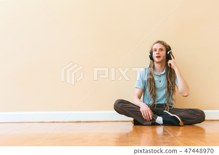 Man listening to headphones in a big room Man listening to headphones in a big room 47448970