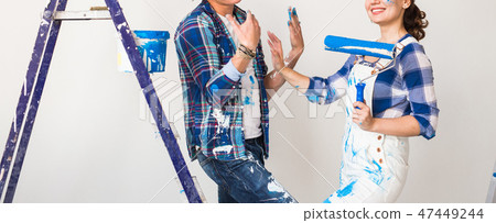 Repair, renovation and love couple concept - young family doing redecoration and painting walls Repair, renovation and love couple concept - young family doing redecoration and painting walls 47449244