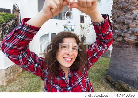 New home, house, property and tenant - Young funny woman holding key in front of her new home after 47449350