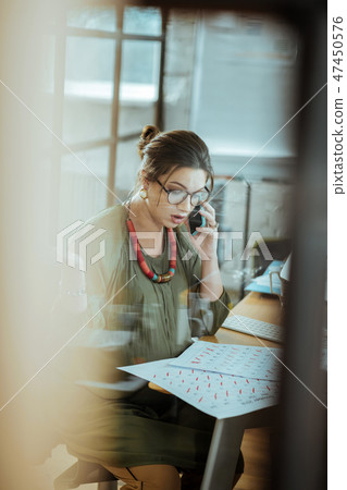Busy businesswoman calling her business partner from office Busy businesswoman calling her business partner from office 47450576