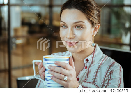 Close up of beautiful woman wearing nice jewelry drinking tea Close up of beautiful woman wearing nice jewelry drinking tea 47450855