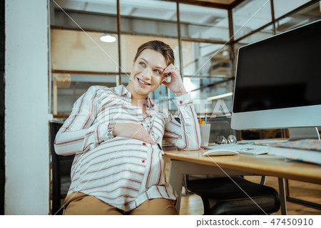 Cheerful young pregnant businesswoman feeling extremely happy 47450910