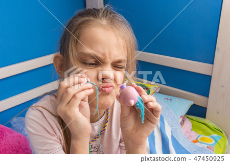 Funny girl trying to fix a toy Funny girl trying to fix a toy 47450925