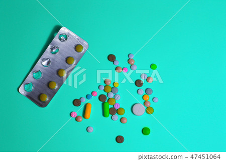 pills, tablets and capsules on wooden spoon.  47451064