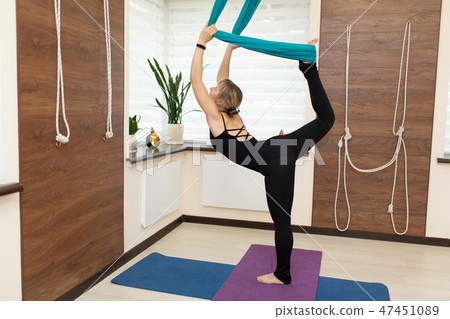 Woman doing fly yoga stretching standing on one  47451089