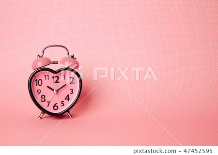 Heart shaped clock on pink background. Heart shaped clock on pink background. 47452595